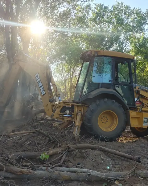 Retroescavadeira amarela limpando um terreno